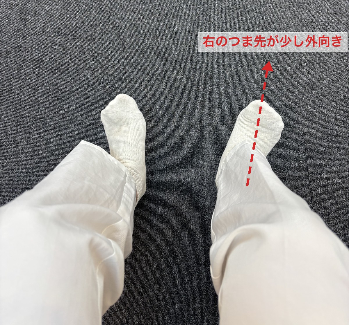 座ったまま足元を見下ろした写真。右のつま先が少し外を向いている