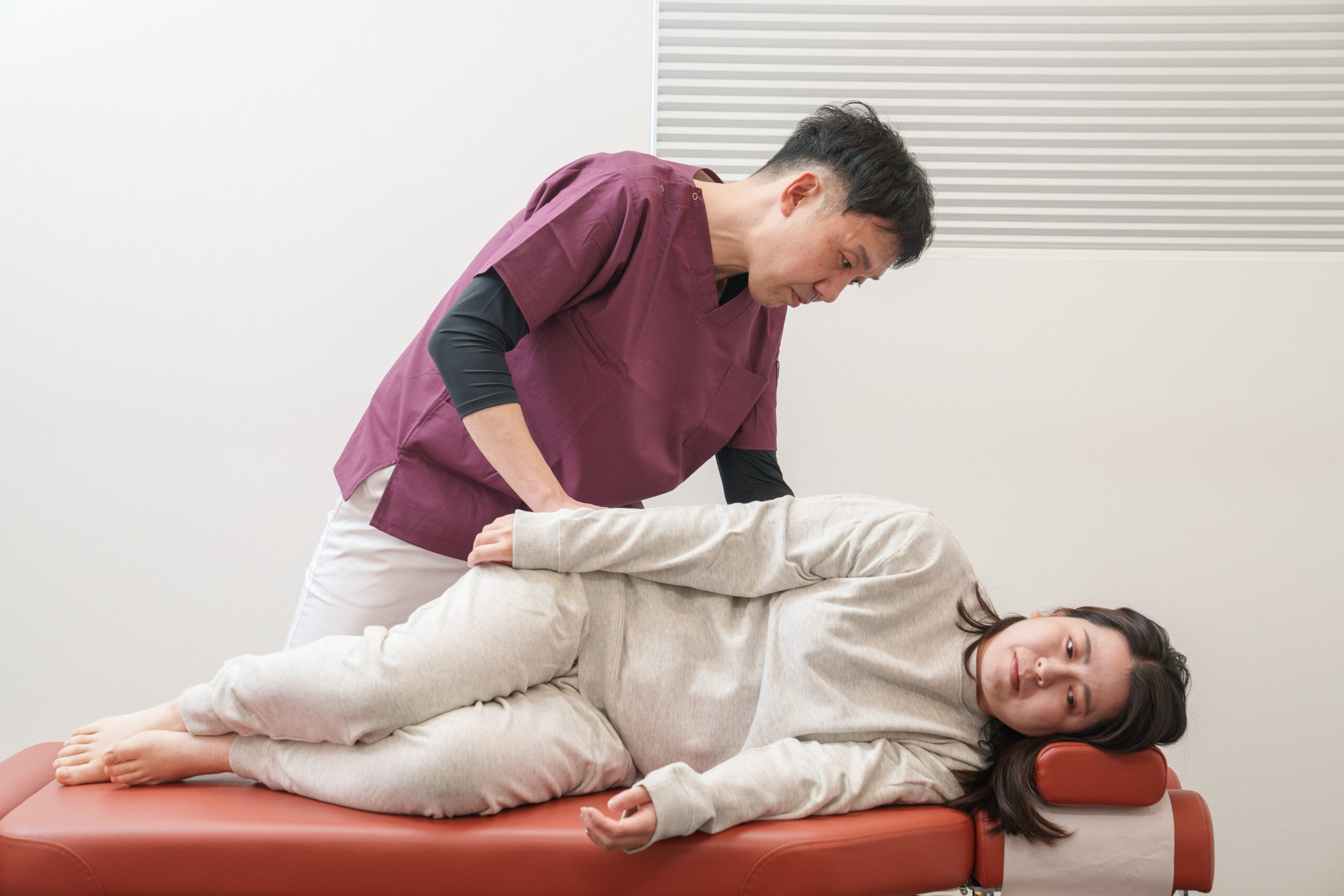 横向きに寝た姿勢で、背骨まわりの動きを一つずつ確かめている様子